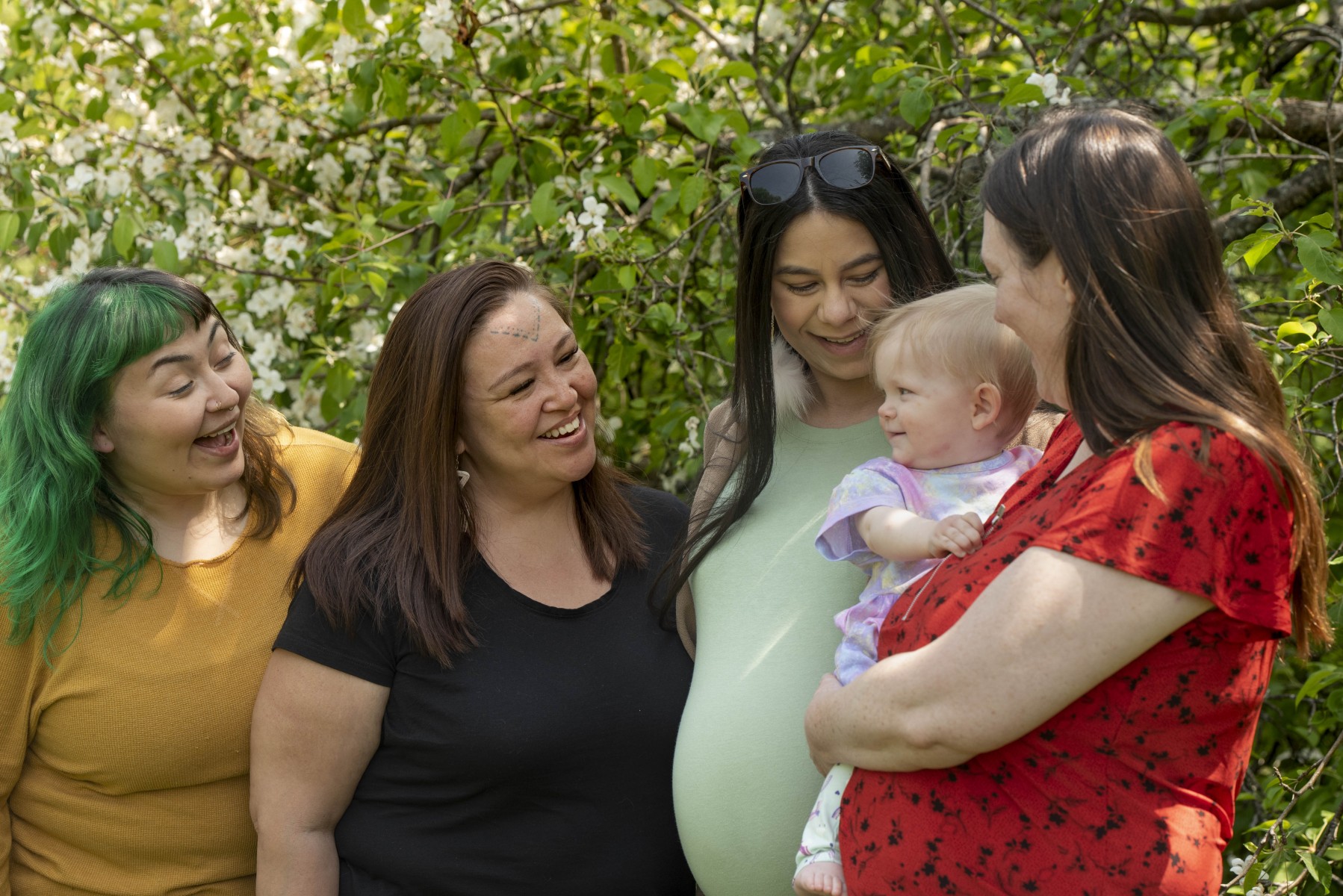 A family group smiles at baby