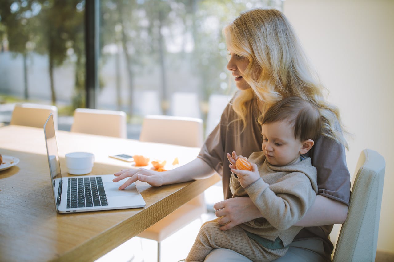 white woman with baby and laptop
