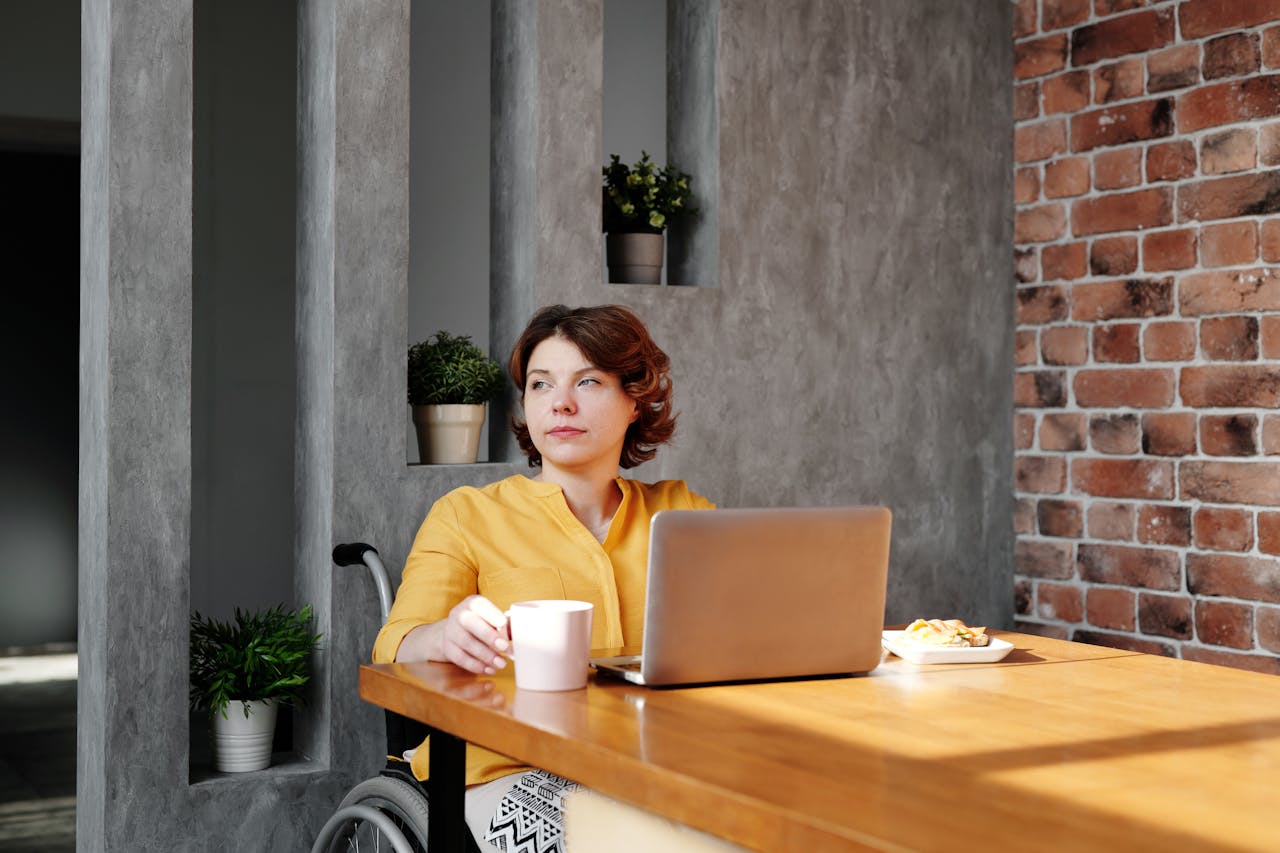 Woman Sitting by the Table While Looking Away with wheelchair
