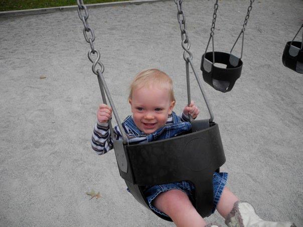 Boy in swing smiling