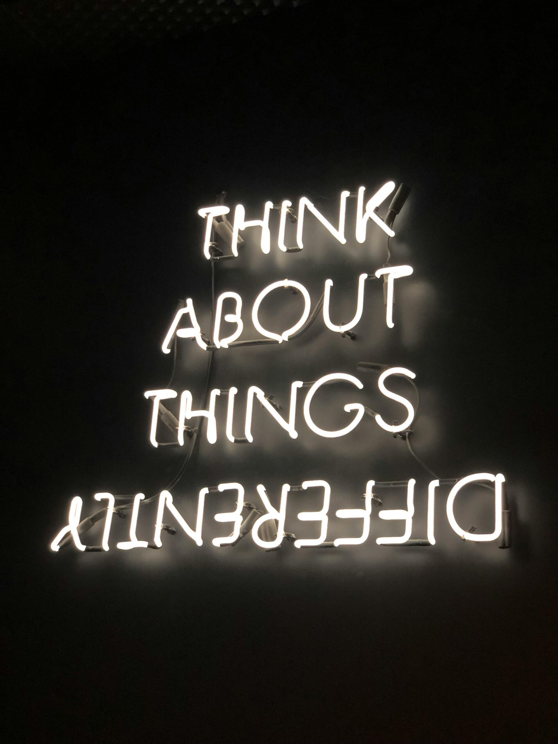 Neon sign that says think about things differently