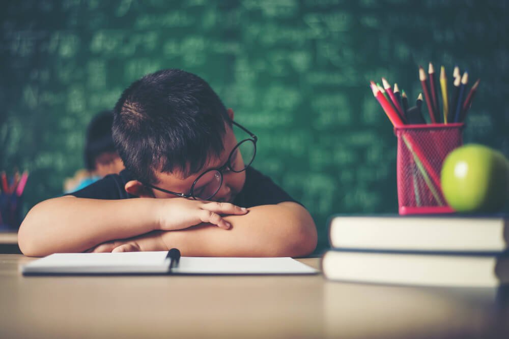 Boy with head down on book